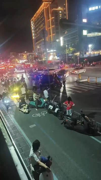 一辆奔驰车行驶在马路中间出现故障，导致交通拥堵，市民齐心协力将车抬到一边，确保交通顺利！