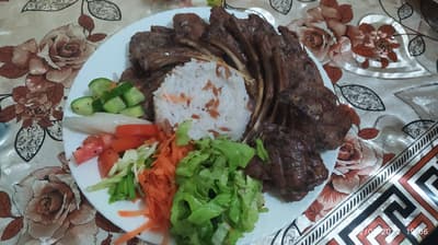 😎🔪 Grilled lamb chops are served with rice pilaf in the center, accompanied by cucumber, tomato, grated carrot, mint, parsley, and radish on the side! 🔪😎